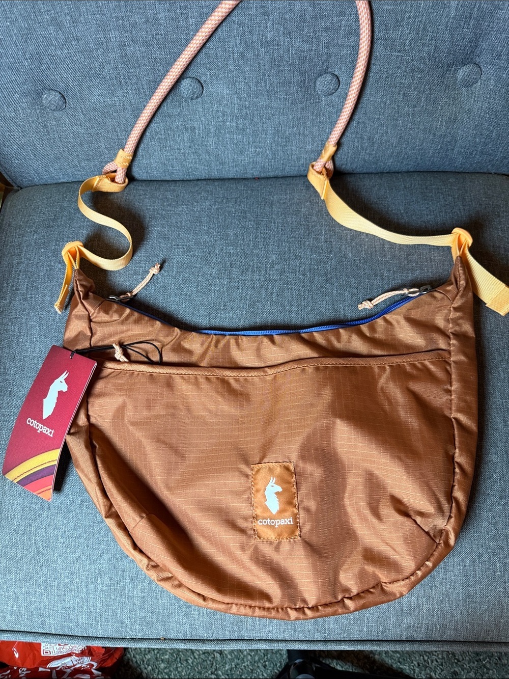 cotopaxi brown sling bag with peach rope and yellow strap